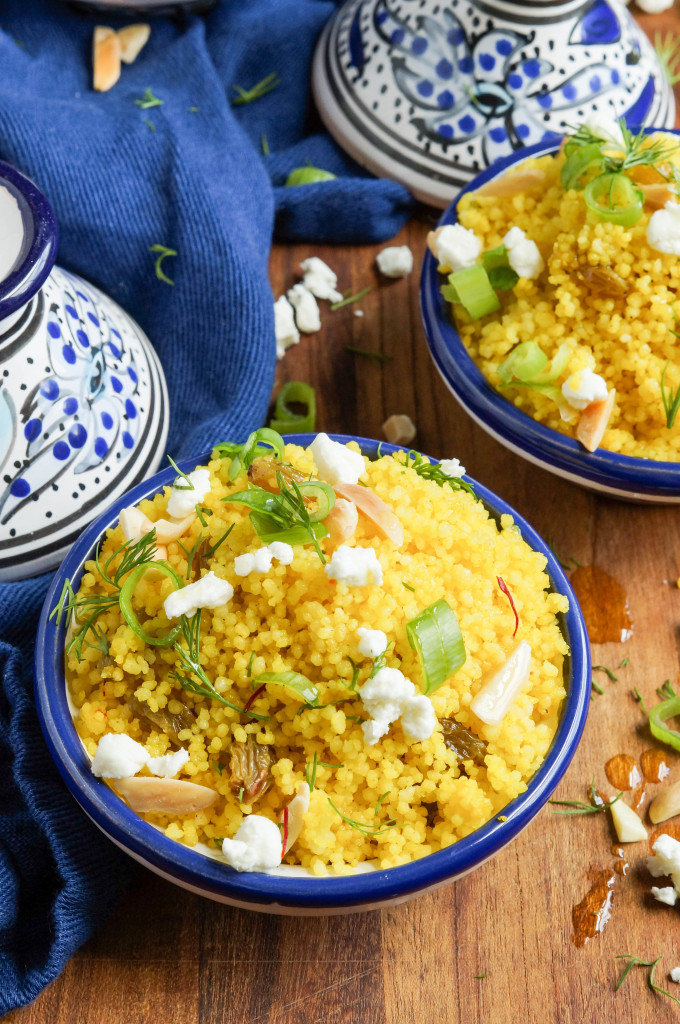 Yellow Couscous Close up of Yellow Couscous in two miniature clay blue/white tagines next to a blue towel.