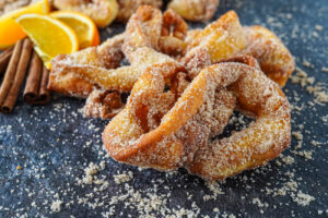 Twisted Filhós à Alentejana (Portuguese Crispy Orange-Flavored Alentejo Pastries) covered in cinnamon sugar.