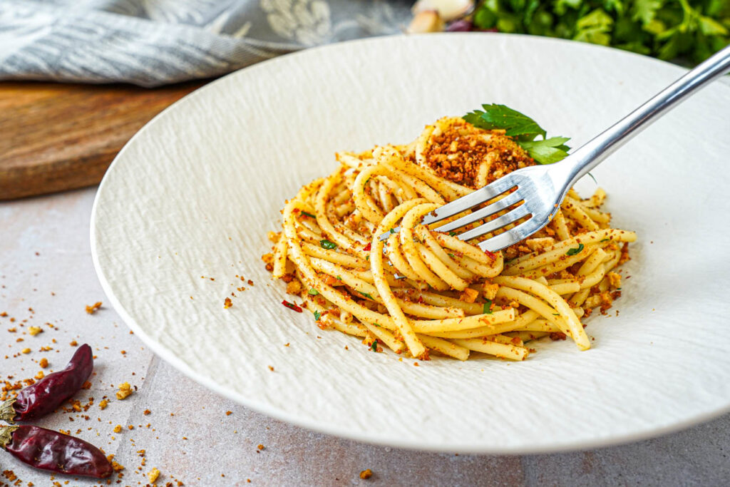 Twirling bucatini with a fork.