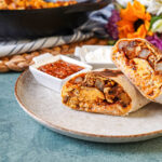 Bacon Breakfast Burritos on a plate with salsa and sour cream.