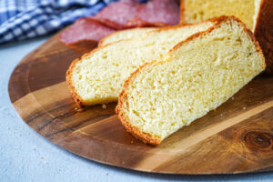 Three slices of Crescia al Formaggio (Italian Easter Cheese Bread) on a wooden board.