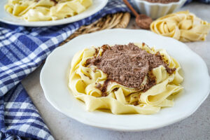 Kakaós Tészta (Hungarian Cocoa Noodles) on a plate with a pile of cocoa powder.