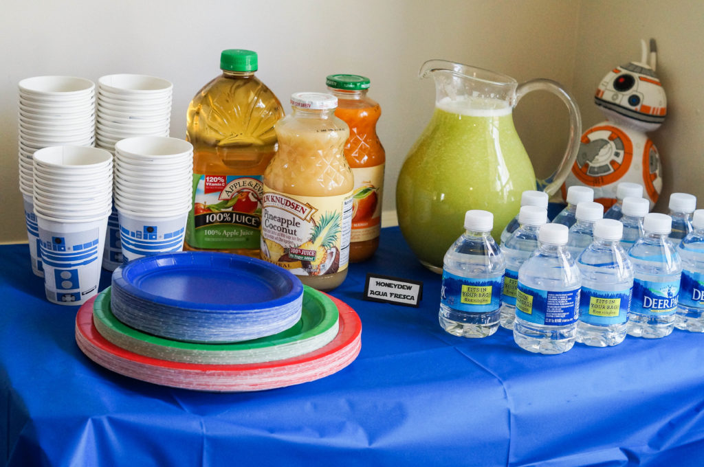 Star Wars Drink Table with water, a glass pitcher, paper plates, and R2D2 Paper cups.