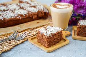 Kärleksmums (Swedish Love Cake) on two wooden boards next to a glass of coffee.