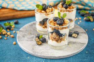 Lemon Blueberry Parfait in three glasses on a marble board.
