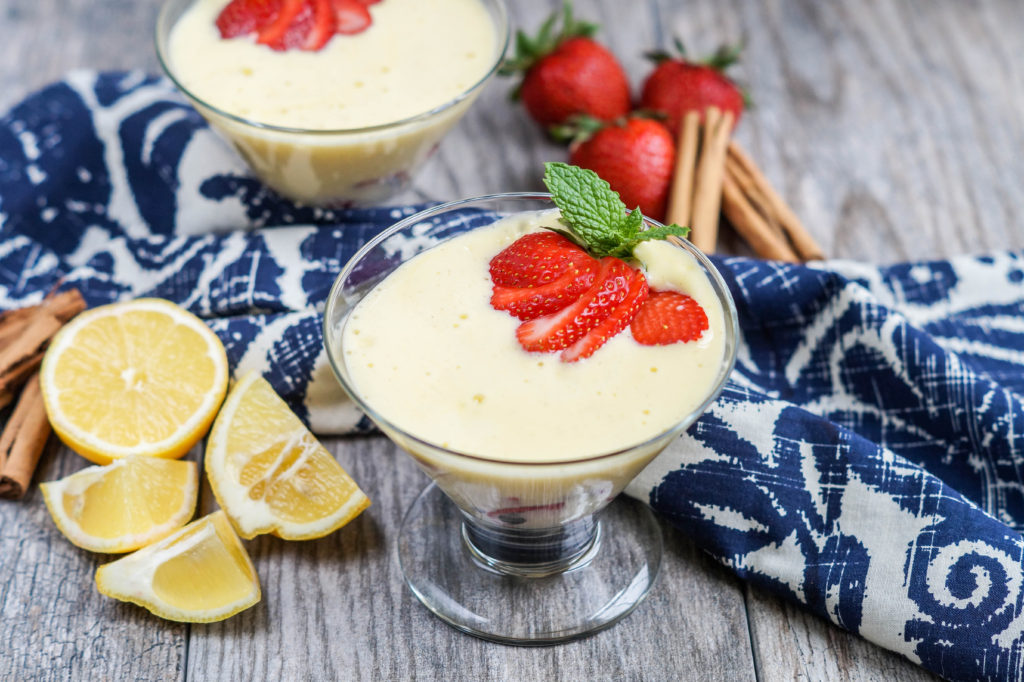 Rieslingsabayon (German Riesling Zabaglione) in two glass bowls and topped with strawberries and mint.