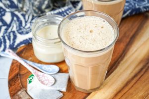 Teh Tarik (Malaysian Pulled Tea) in two tall glasses next to condensed milk.