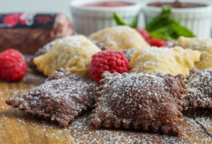 Plain and Chocolate Fried Ravioli with Raspberry Chocolate Goat Cheese on a wooden board