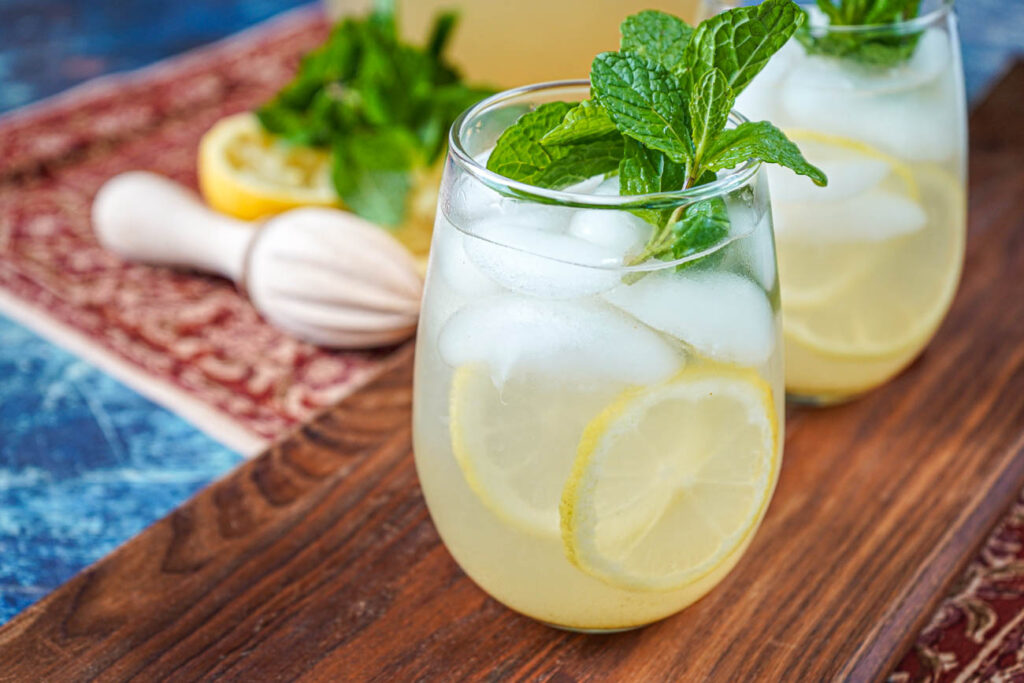 Shikanji (Indian Spiced Lemonade) in two glasses with fresh mint sprigs.