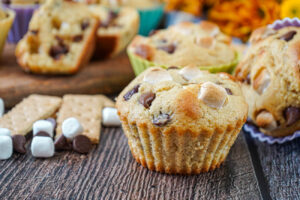 S'mores Muffins next to graham crackers, mini marshmallows, and milk chocolate chips.