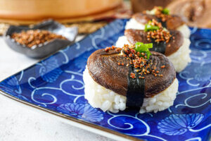 Three Shiitake Nigiri on a blue plate.