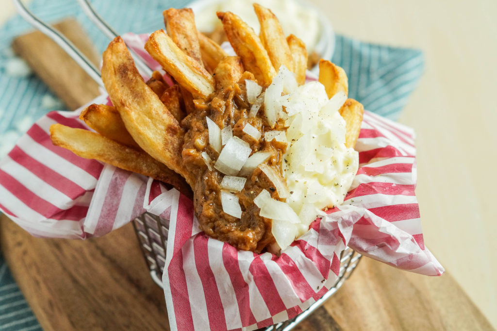 Patatje Oorlog (Dutch War Fries) in a basket with red and white striped napkin
