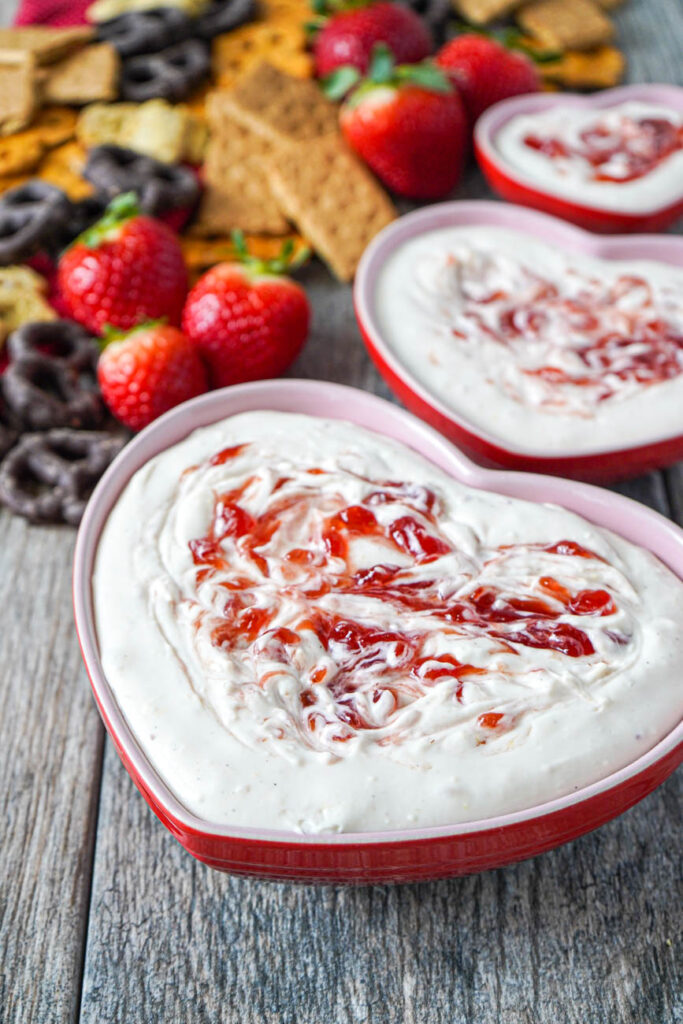 Close up view of Strawberry Cheesecake Dip in three heart shape bowls.