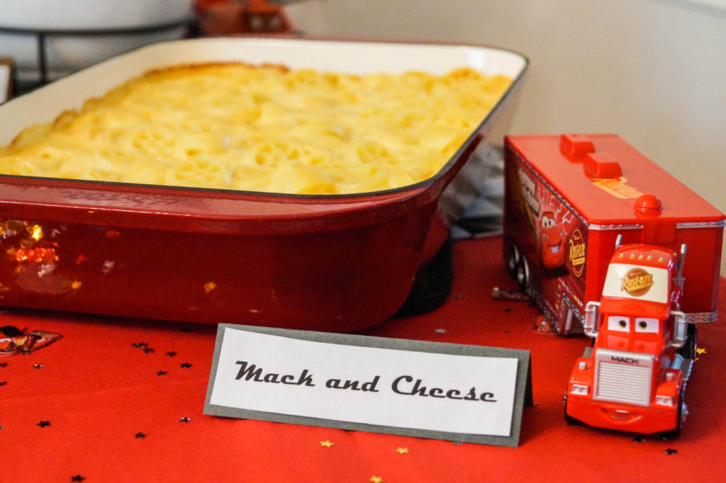 Macaroni and Cheese in red pan with sign- Mack and Cheese.