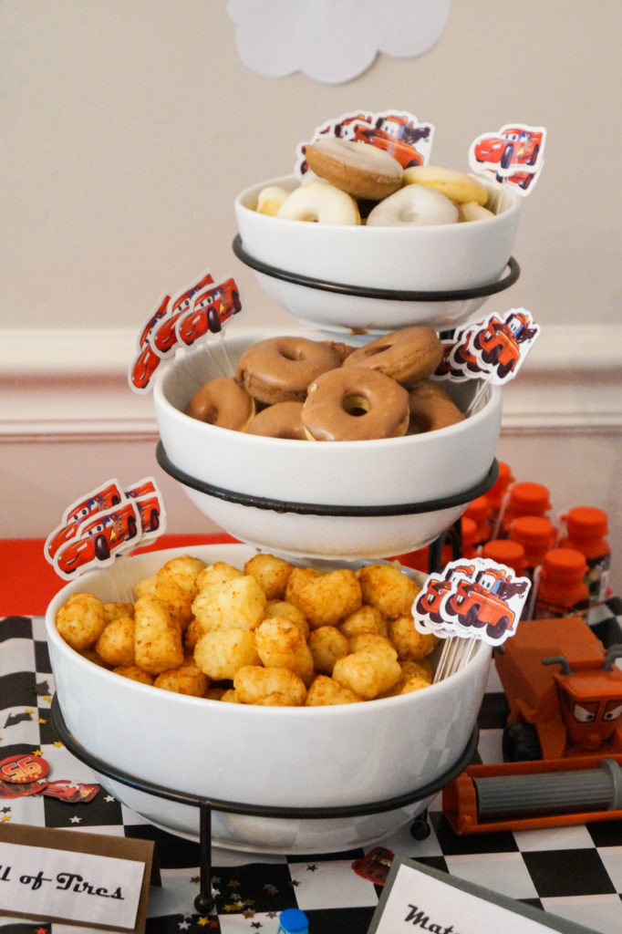 Tater tots and mini doughnuts in white bowls.