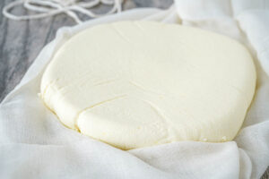 A round of Paneer Cheese on a piece of cheesecloth.