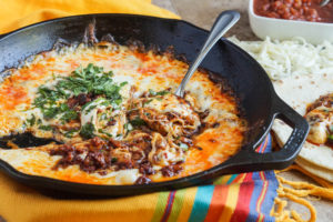 Queso Fundido (Melted Cheese with Chorizo) in a cast iron skillet.