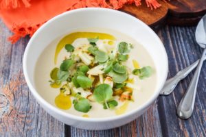 Moorish Chilled Almond and Orange Blossom Soup with Apple and Watercress Dressing in a white bowl.