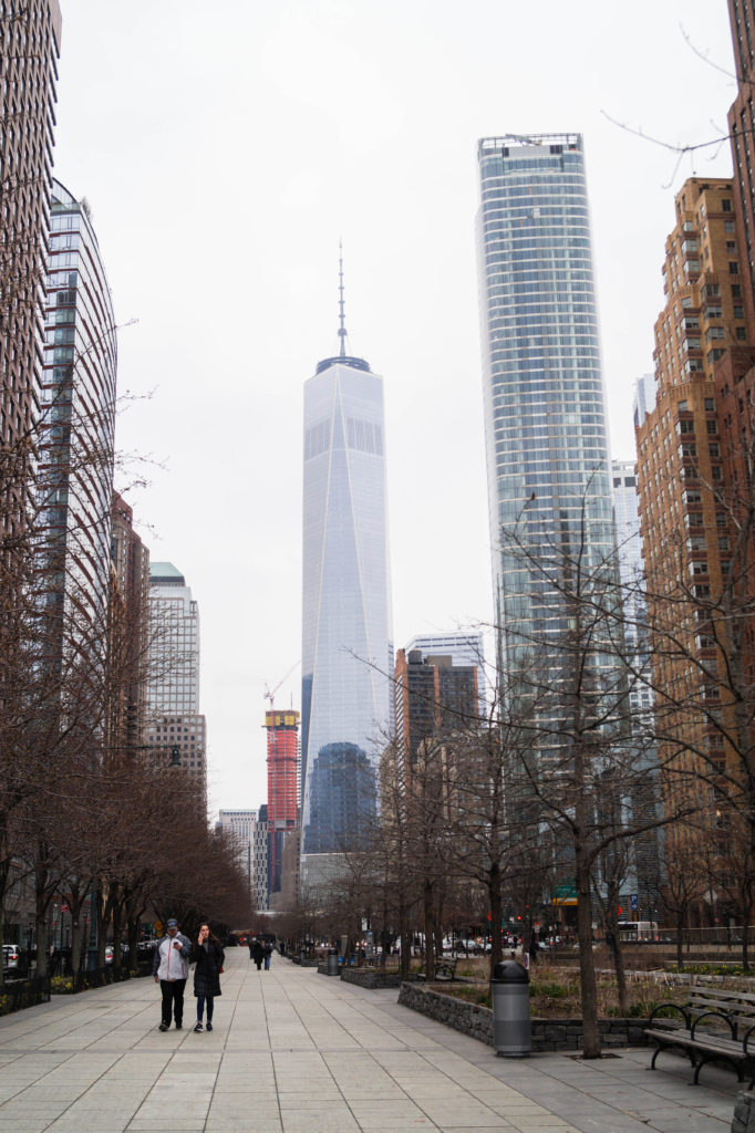 View down New York City Street with One World Trade Center in the background.