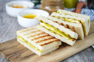 Four Kaya Toast (Toast with Coconut Jam and Butter) on a wooden board.