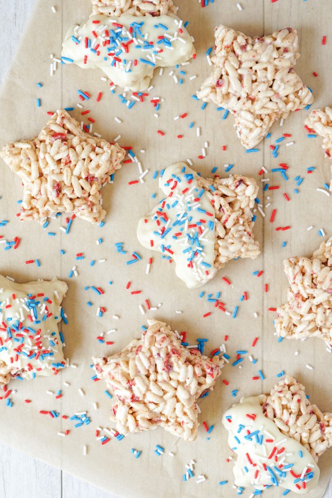 Aerial view of Berry Rice Krispies Treats- half dipped in white chocolate and covered in sprinkles.