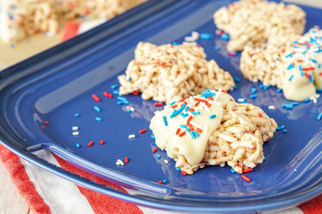 Berry Rice Krispies Treats on a blue platter over a red and white striped towel.