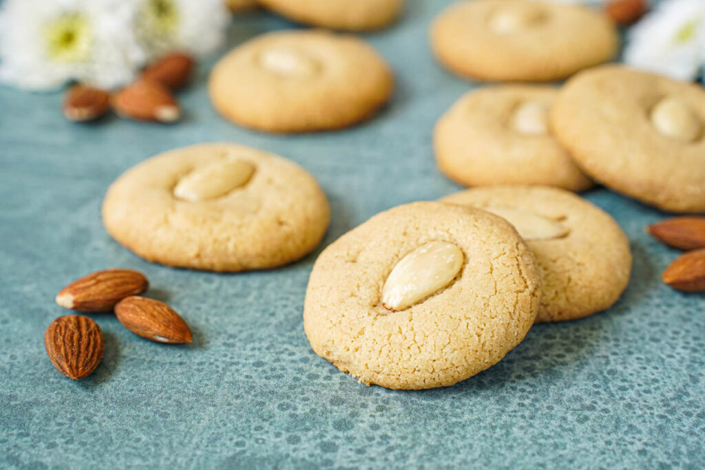 Tahina Cookies next to almonds and white flowers.