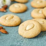 Tahina Cookies next to almonds and white flowers.