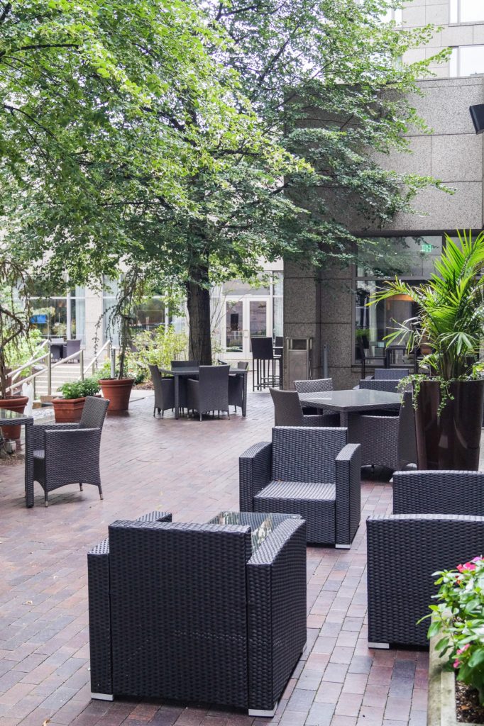 Courtyard at The Logan Hotel with armchairs situated around small tables.