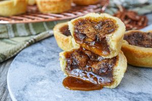 Canadian Butter Tarts on a marble slab cut in half to show the runny filling.