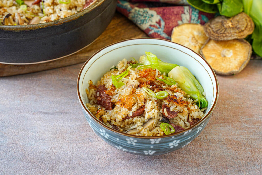 Clay Pot Chicken Rice in a bowl with pieces of the crispy rice on top.
