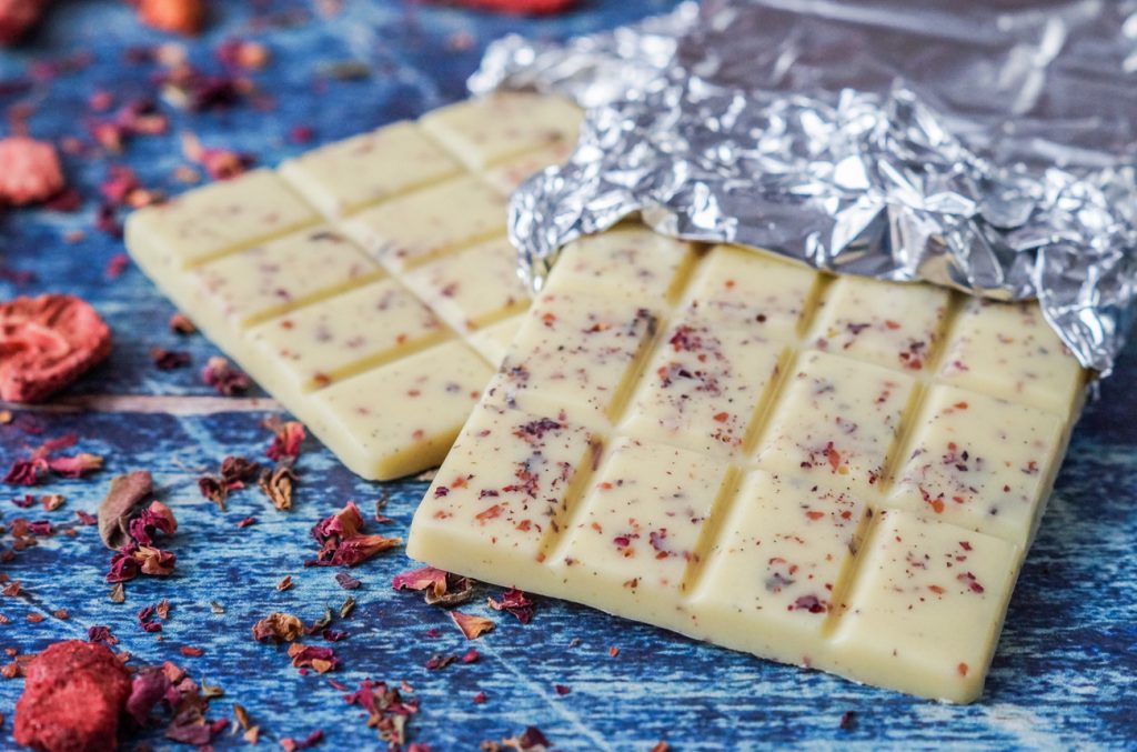 Homemade White Chocolate with Strawberries and Rose Petals formed into two bars.