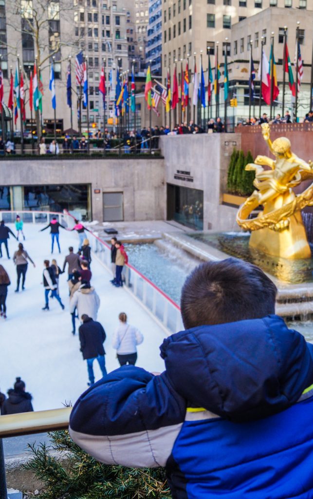 Boy looking at ice skating rink in Rockefeller Center.