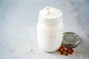 Marshmallow Whip in a large jar next to a top and three pansies.