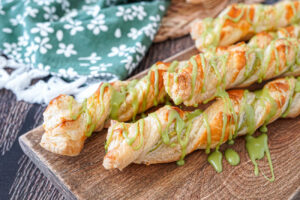 Four Matcha Puff Pastry Twists on a wooden board.