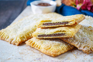Chocolate Hazelnut Toaster Pastries on a marble board with one cut in half to show chocolate hazelnut filling.