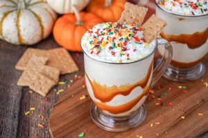 Pumpkin Spice Milkshake in two glasses with pumpkins in the background.