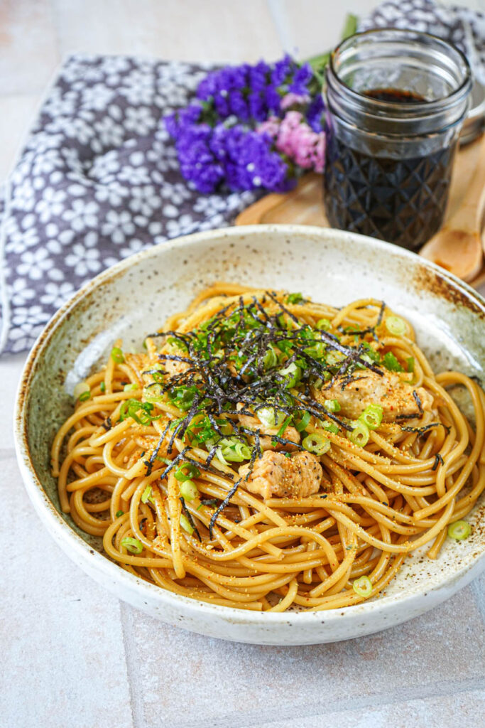 Chicken Teriyaki Pasta in a bowl next to a jar of Homemade Teriyaki Sauce.