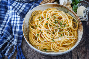 Pasta with Garlic Butter Sauce in a bowl with chopped parsley and grated parmesan.