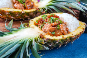 Pineapple Teriyaki Chicken in two pineapple halves with steamed white rice.
