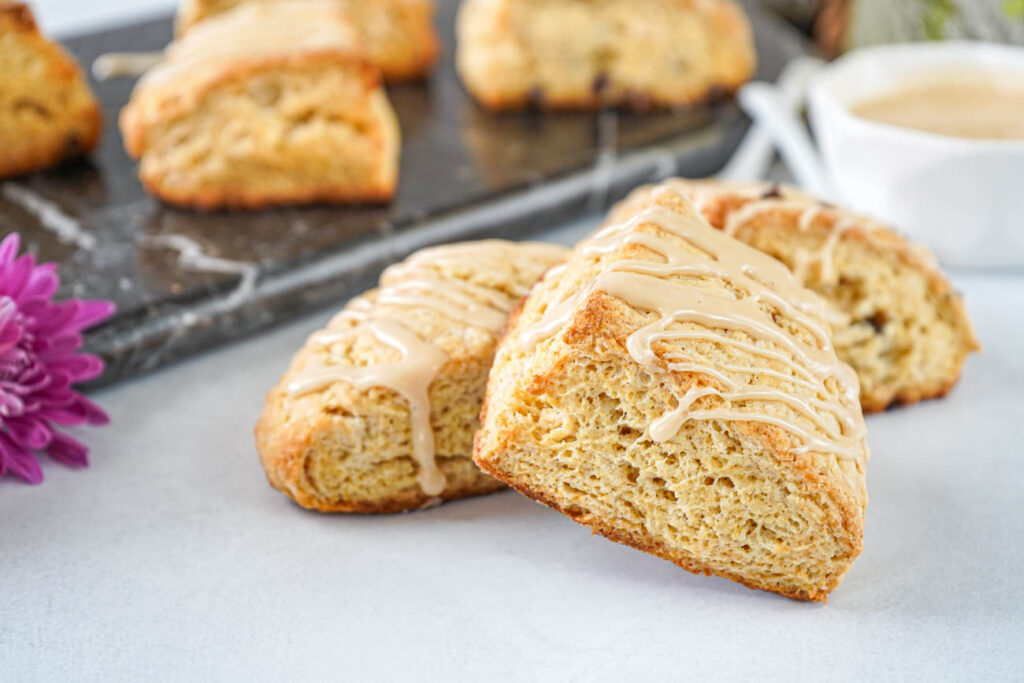 Three Irish Cream Scones with more in the background on a marble board.