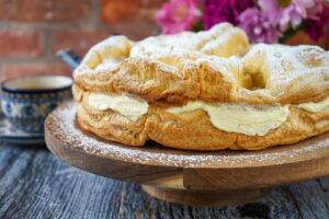 Karpatka (Polish Carpathian Cream Cake) on a wooden stand and covered with powdered sugar.