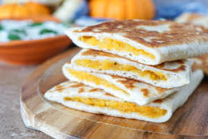 Bolani Kadoo (Afghan Pumpkin Stuffed Flatbread) in a stack with the pumpkin filling showing.