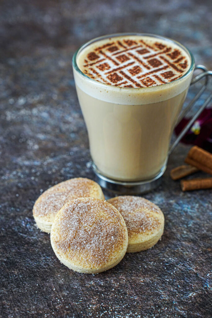 Three Biscotti Diamante next to a glass of coffee.