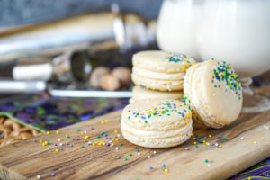 Four Brandy Milk Punch Macarons on a wooden board.