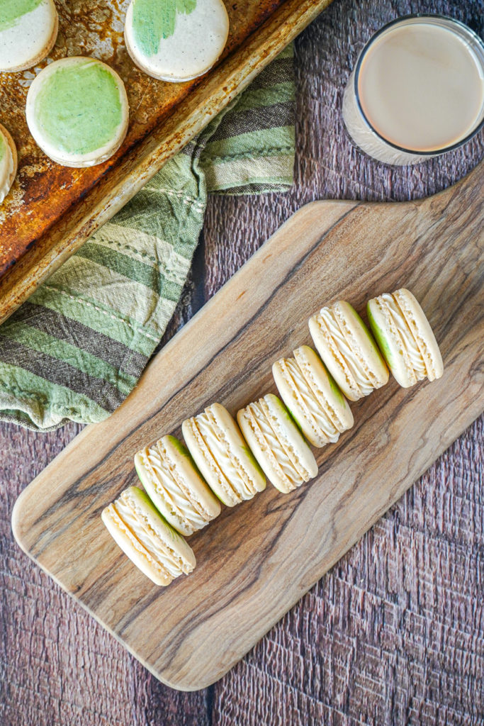 Irish Cream Macarons Aerial view of Irish Cream Macarons lined up on a wooden board.