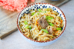 Tsuivan (Mongolian Noodles with Meat and Vegetables) in a blue and brown bowl.