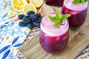 Mint Blackberry Lemonade (Limonada de Mora y Menta) in two glasses with mint sprigs.
