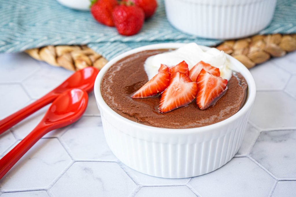 Spiced Cacao Manna Porridge Spiced Cacao Manna Porridge in a white bowl with strawberries and creme fraiche.