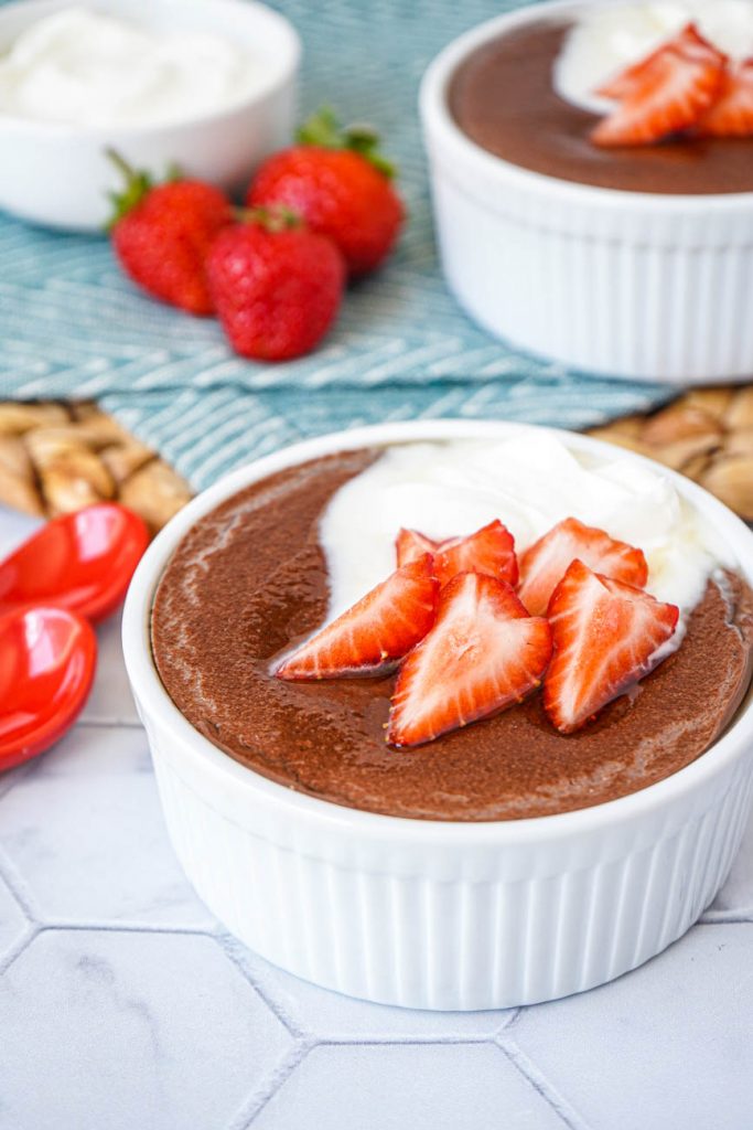 Spiced Cacao Manna Porridge Close up of Spiced Cacao Manna Porridge in two white bowls next to red spoons.